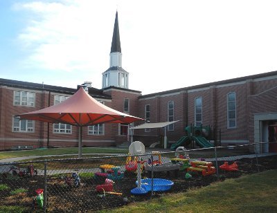 Image of an umbrella shade structure at church daycare playground.